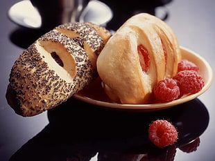 selective focus photography of two baked breads serve on brown ceramic plate