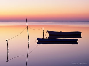 silhouette of boat on body of water under orange sunset HD wallpaper