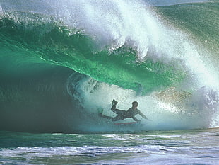 high speed photography of man surfing under a sea wave