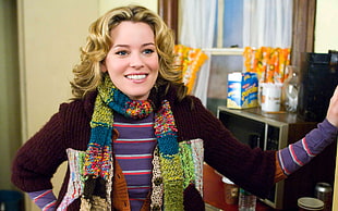 smiling woman wearing maroon sweater and multicolored scarf at daytime