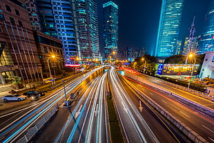 Timelapse Photography of Vehicle on Concrete Road Near in High Rise Building during Nighttime HD wallpaper