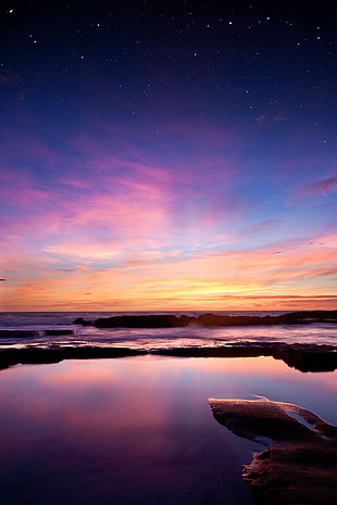 sunset near sea with starry skies