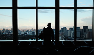 silhouette photo of person wearing jacket inside building