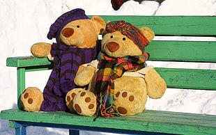 photo of two brown bears on green wooden bench