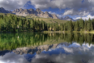 photo of body of water surrounded by trees and mountains, lago