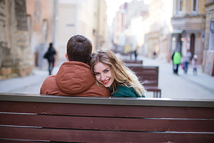 man and woman sitting on bench in outdoor place during daytime