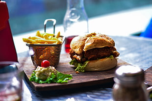 selective focus photography of burger and french fries on brown tray