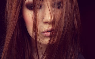 close up photo of red haired woman with silver-colored lip piercing