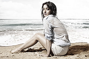 woman sitting on sand at seashore HD wallpaper