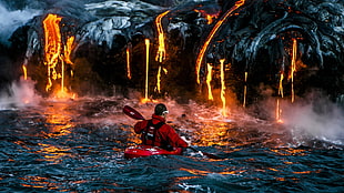 man wearing red jacket riding on red kayak