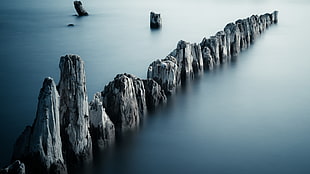 aligned stone formations on body of water