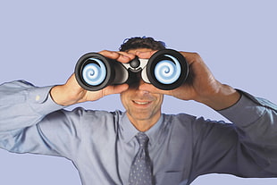 man wearing blue dress shirt and necktie using black and white binoculars