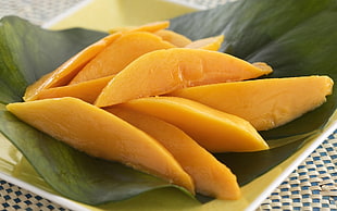 sliced mango on green leaf plant