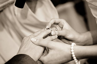 sepia photography of groom and bride wearing ring