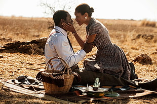 man and woman having picnic at desert during daytime