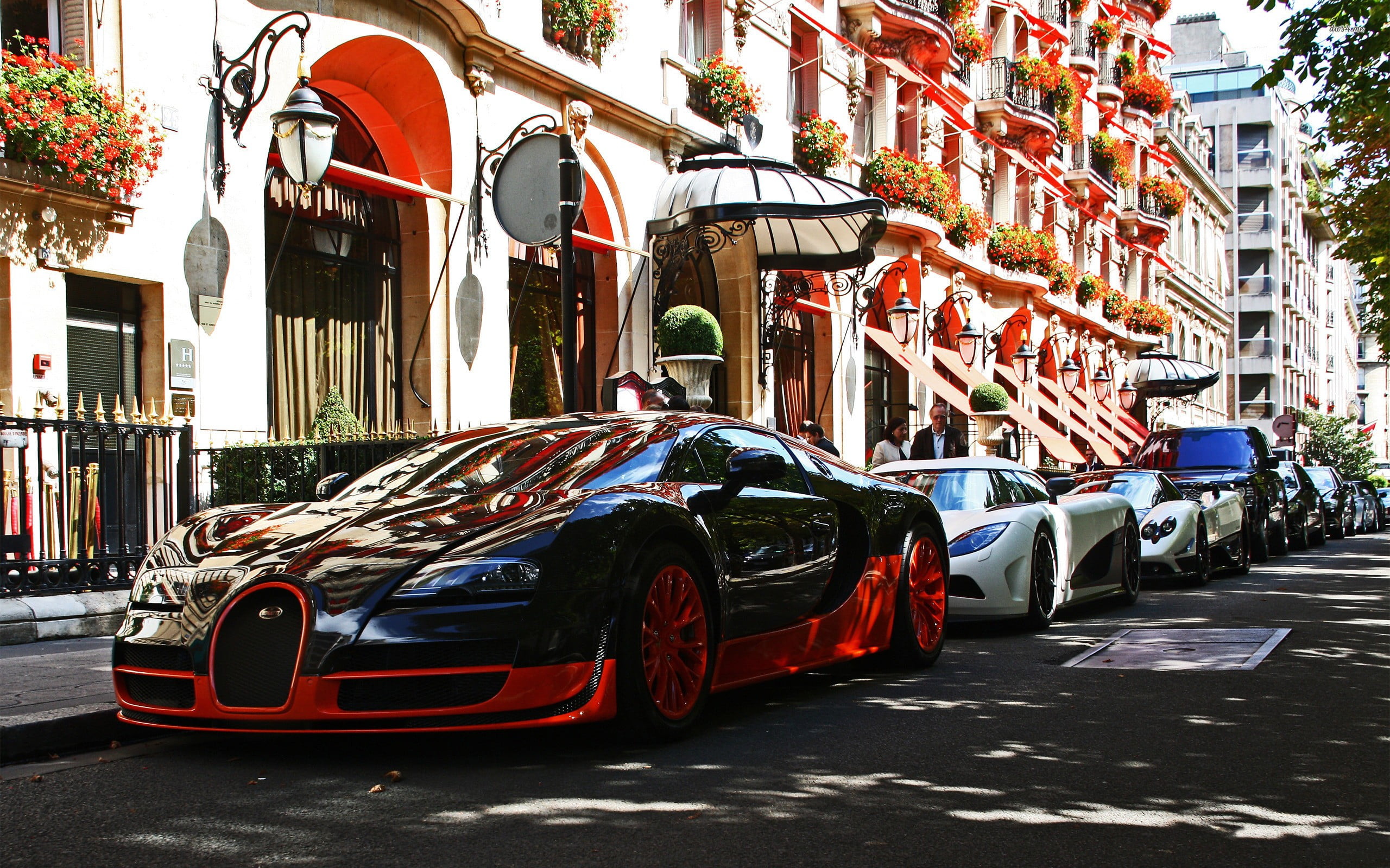 red and black Bugatti Veyron beside concrete structure