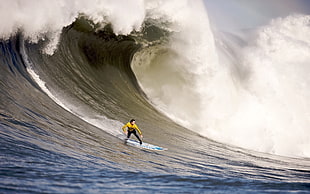 person wearing yellow rashguard riding a surfboard on wave HD wallpaper