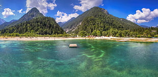 brown wooden beach hut on calm sea near mountains with green trees during daytime
