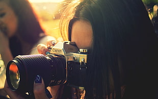 woman taking photo with Canon DSLR camera HD wallpaper