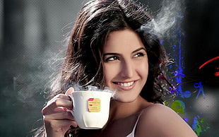 woman holding white ceramic cup white smiling