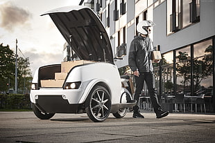 person standing beside trike near house