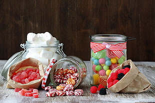 variety of candies in jars on gray wooden surface HD wallpaper