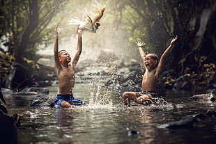 two boys bathing on body of water HD wallpaper