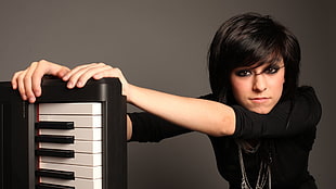 woman in black sweater holding black electronic keyboard HD wallpaper