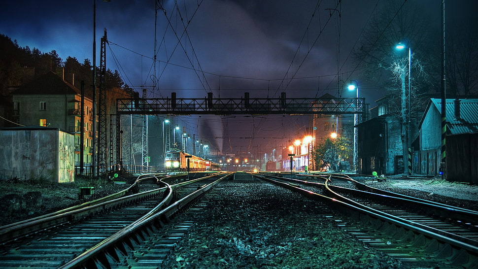 train rails photo during nighttime HD wallpaper