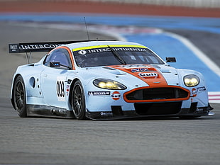 white Aston Martin GT sports car on asphalt road