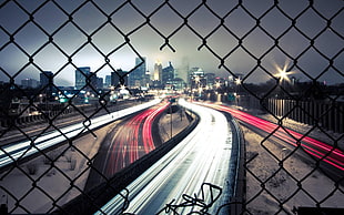 black chain-link fence, photography, long exposure, cityscape, city