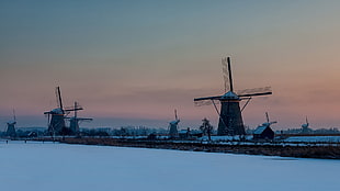 white windmill surrounding by snow field