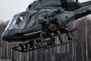 gray helicopter with two soldiers