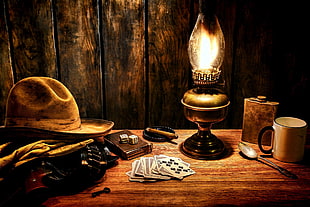 cowboy hat beside kerosene lamp illustratio