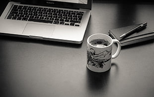 gray laptop computer near ceramic mug