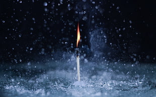 time lapse photography of candle between dropping water