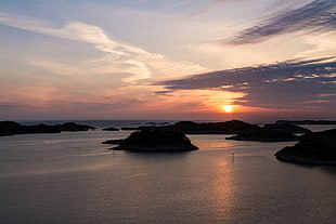 silhouette of island under sunset with clouds