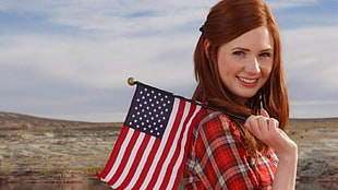 woman holding flag of America during daytime