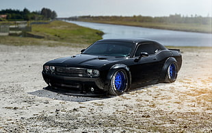 black Ford mustang on the sand HD wallpaper