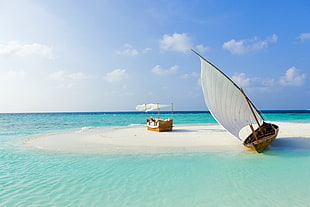 boat on white sand island during daytime
