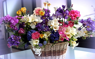 variety of flowers in basket at table