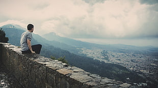 man sitting on concrete structure looking the view