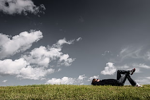 men in black shirt lying on green grass during daytime
