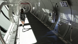 woman in black and white long-sleeved mini dress walking inside tunnel