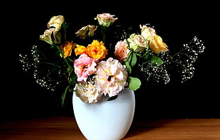 pink, yellow, and white Roses in white vase centerpiece