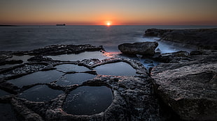 close up photo of black rock formation beside sea during golden hour, marsaskala, malta HD wallpaper