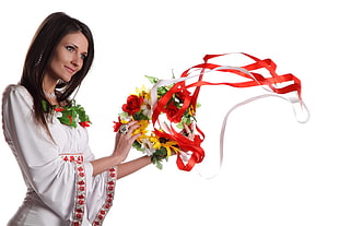woman in white and red long sleeved dress holding green and red wreath