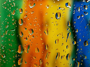 selective focus of blue, yellow, orange, and green panels with water drops