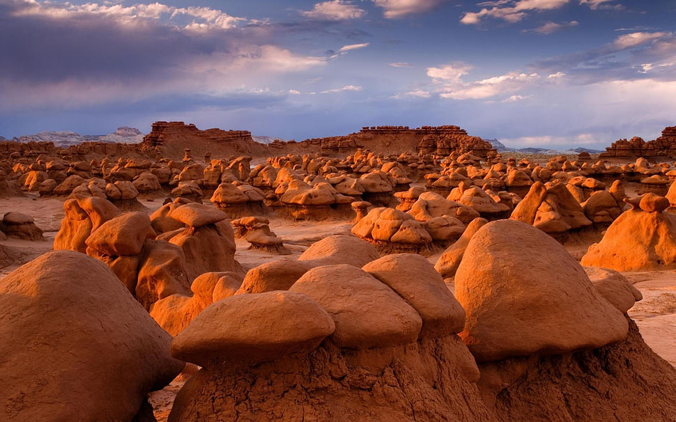 brown stone formation under orange sunset HD wallpaper