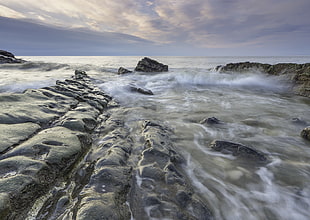 time laps photography of water near gray rocks